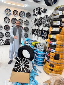 City Wheels owner in the G-10/1 showroom beside a wall of alloy rims
